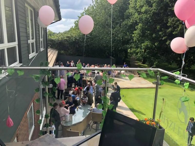 Guests celebrating on the clubhouse balcony decorated with balloons